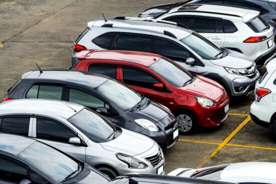 Cars outside in a used car parking lot.
