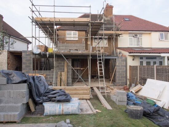 Two story house with scaffolding outside because it's being renovated