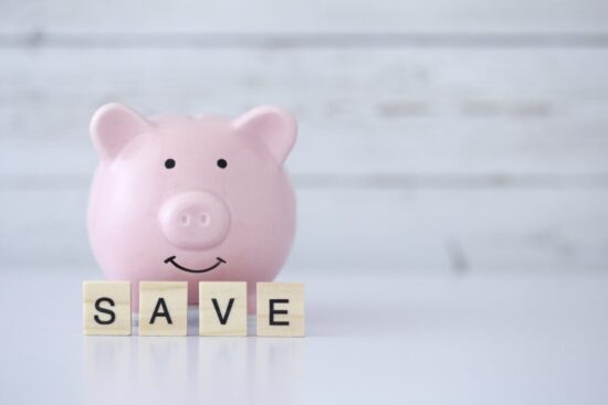 Piggybank with tiles in front of it that read "SAVE"