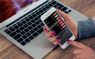 holding phone with investing apps