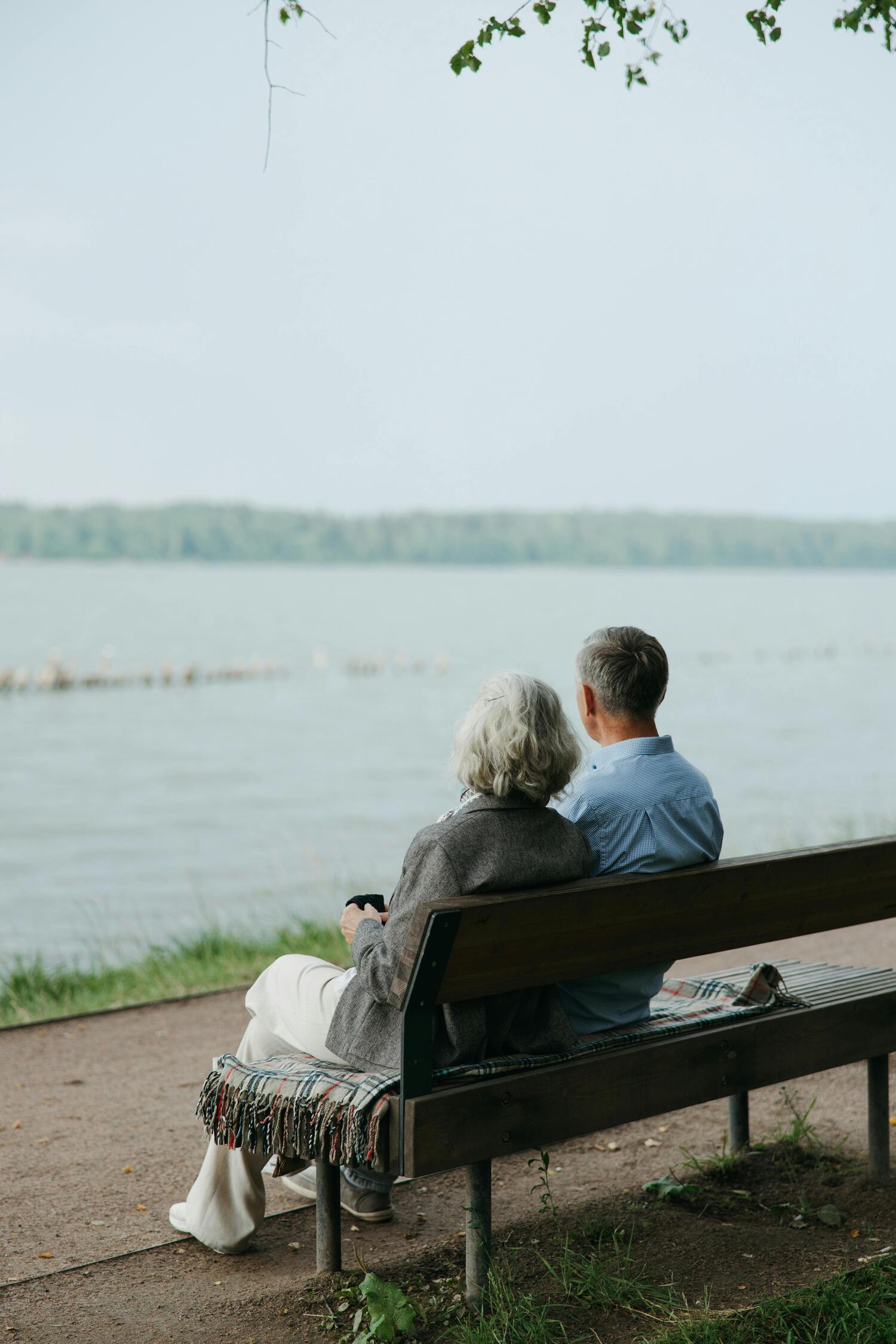 older couple sitting by a lake