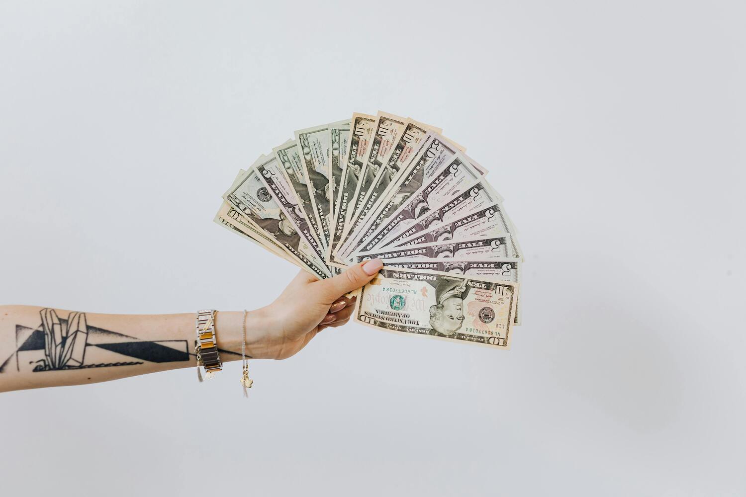 money fanned out, hand holding money