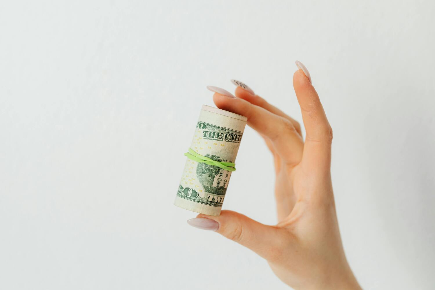 roll of money, hand holding bundle of money