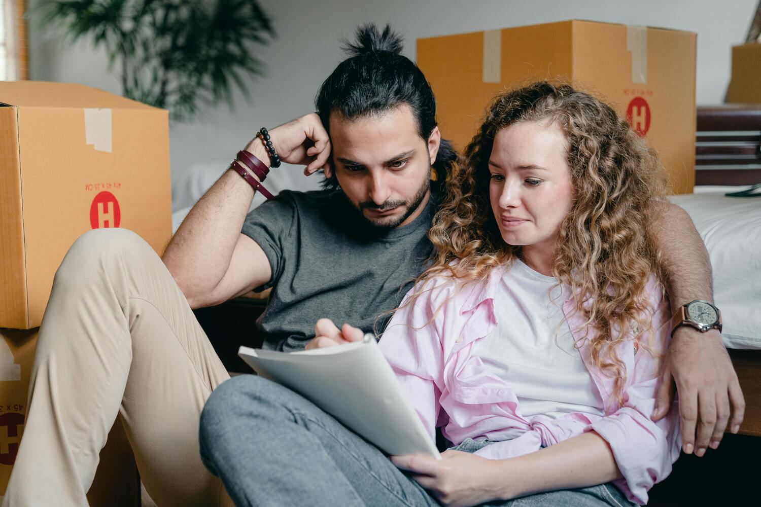 couple sitting together on the couch going over paperwork