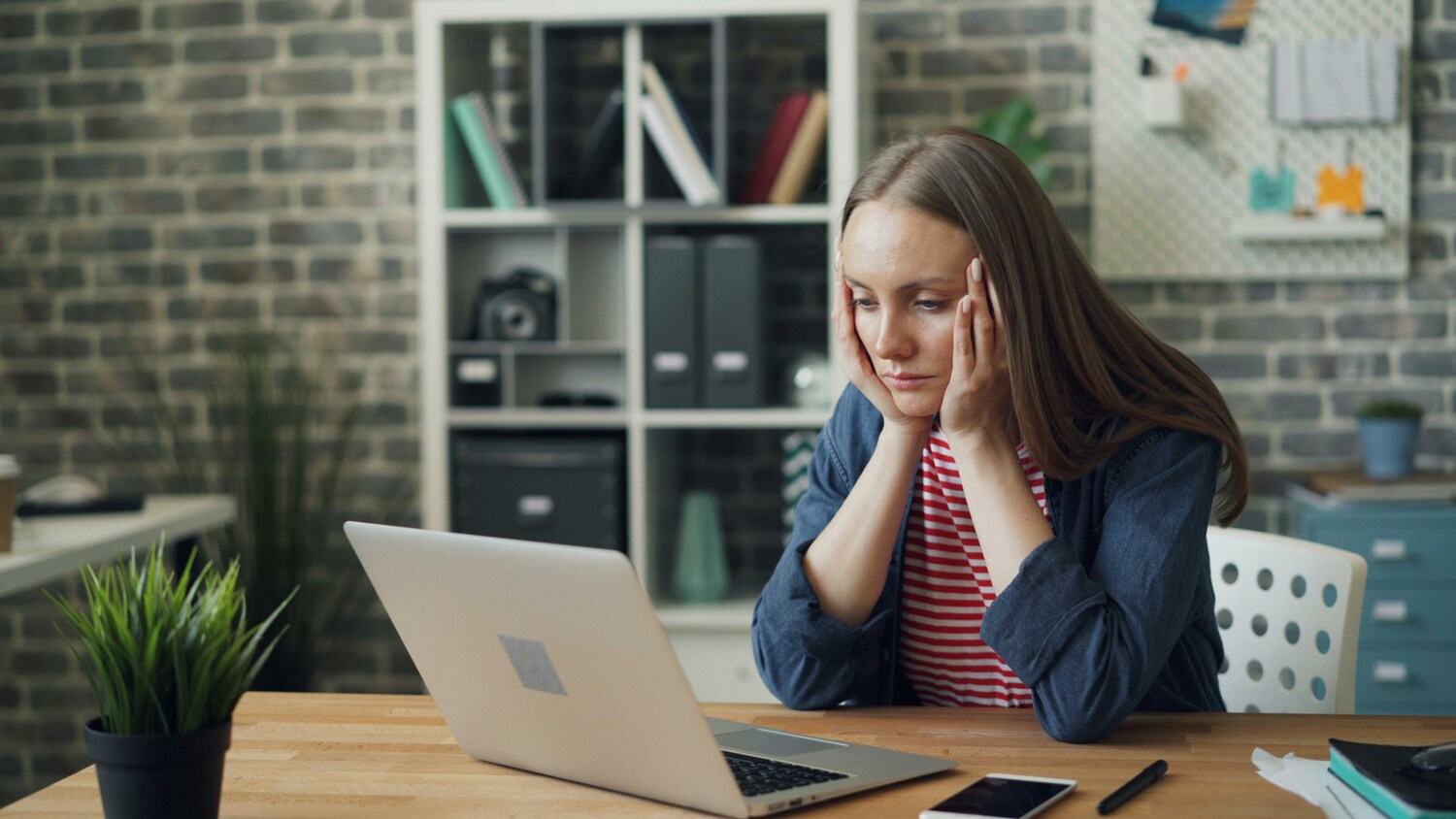 fatigued, tired woman sitting at a desk