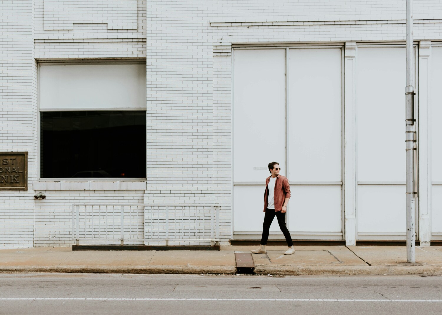 man walking across the street