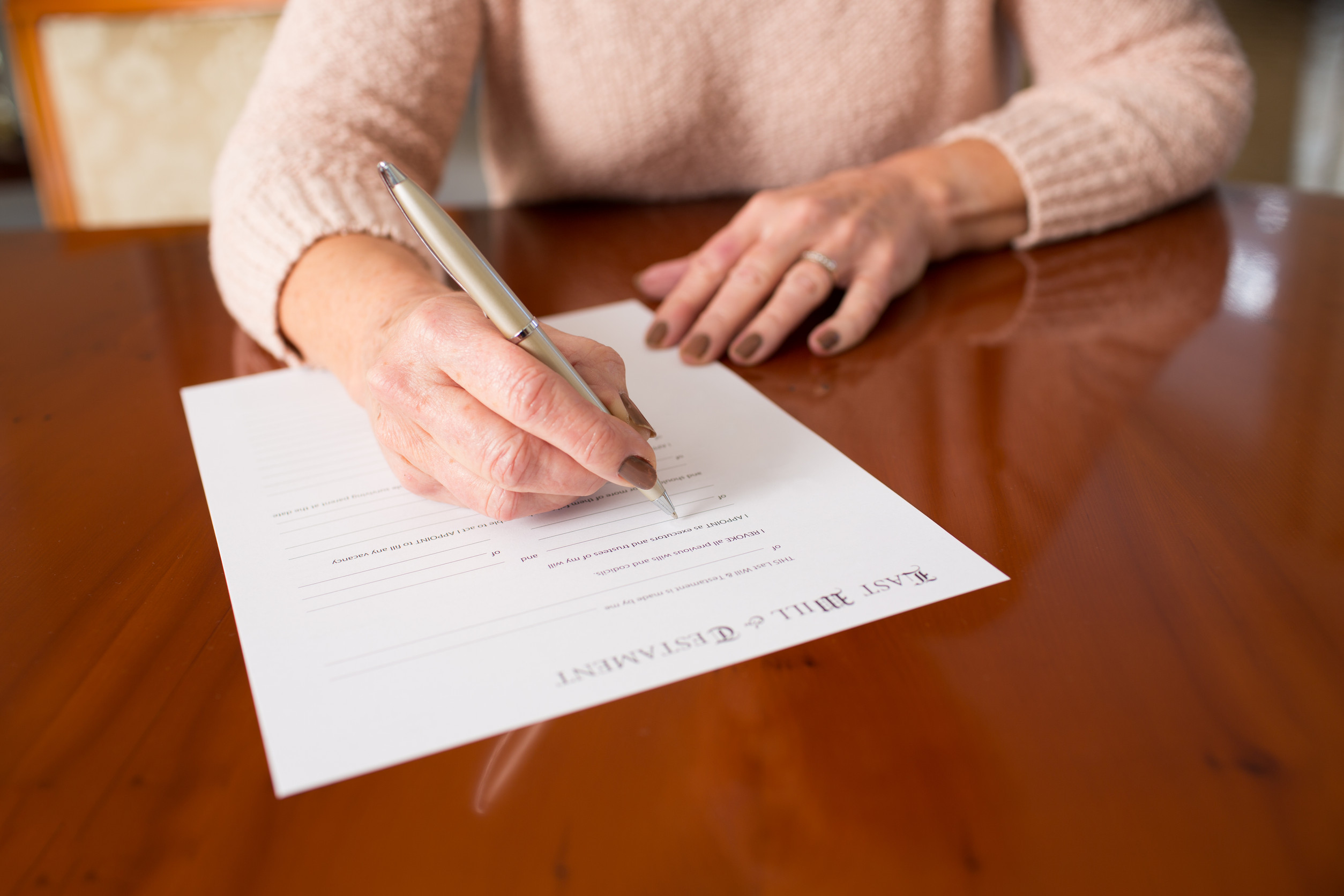 senior woman signing updated will